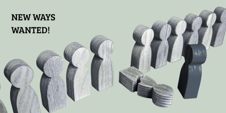 Gleichförmige Holzfiguren stehen aufgereiht nebeneinander, eine Figur ist umgefallen und zerbrochen. Vor der Reihe steht eine andersfarbige Holzfigur. Symbolbild für ein starres Schulsystem und die Notwendigkeit von Schulentwicklung.
